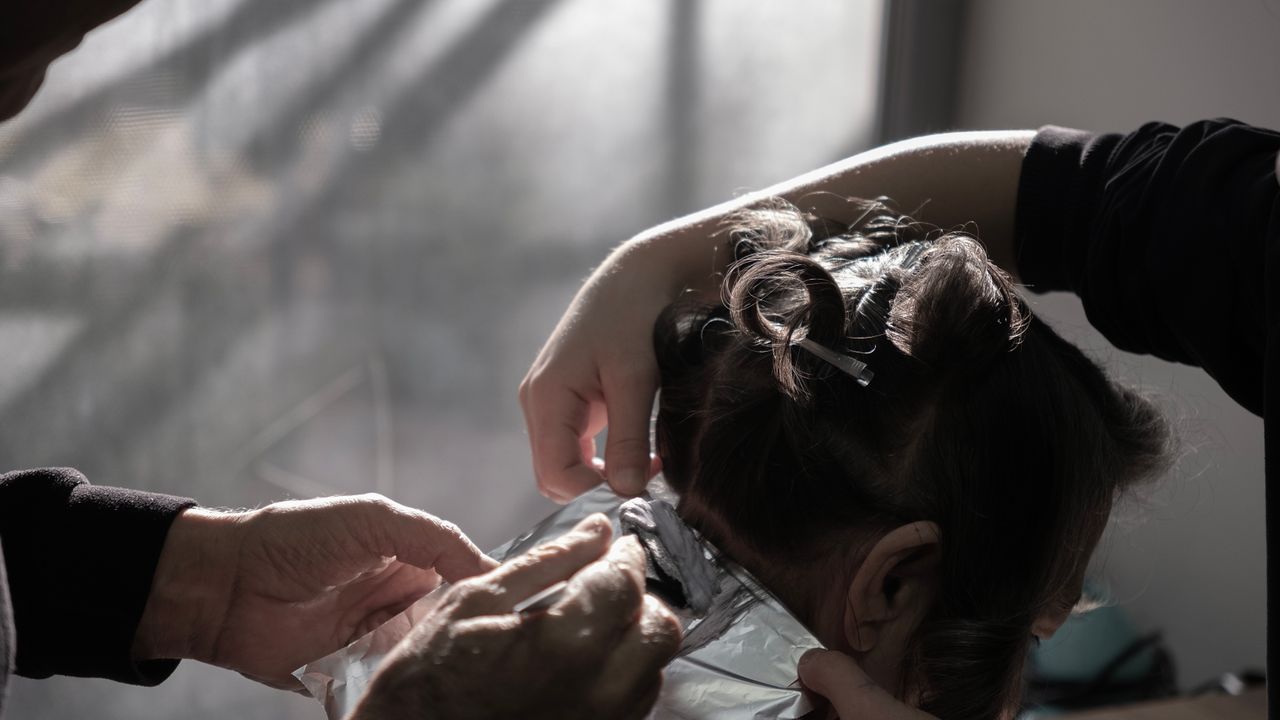 Profissional colorista aplicando técnica em salão de beleza premium
